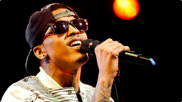 August Alsina, en un escenario, brindando un concierto.